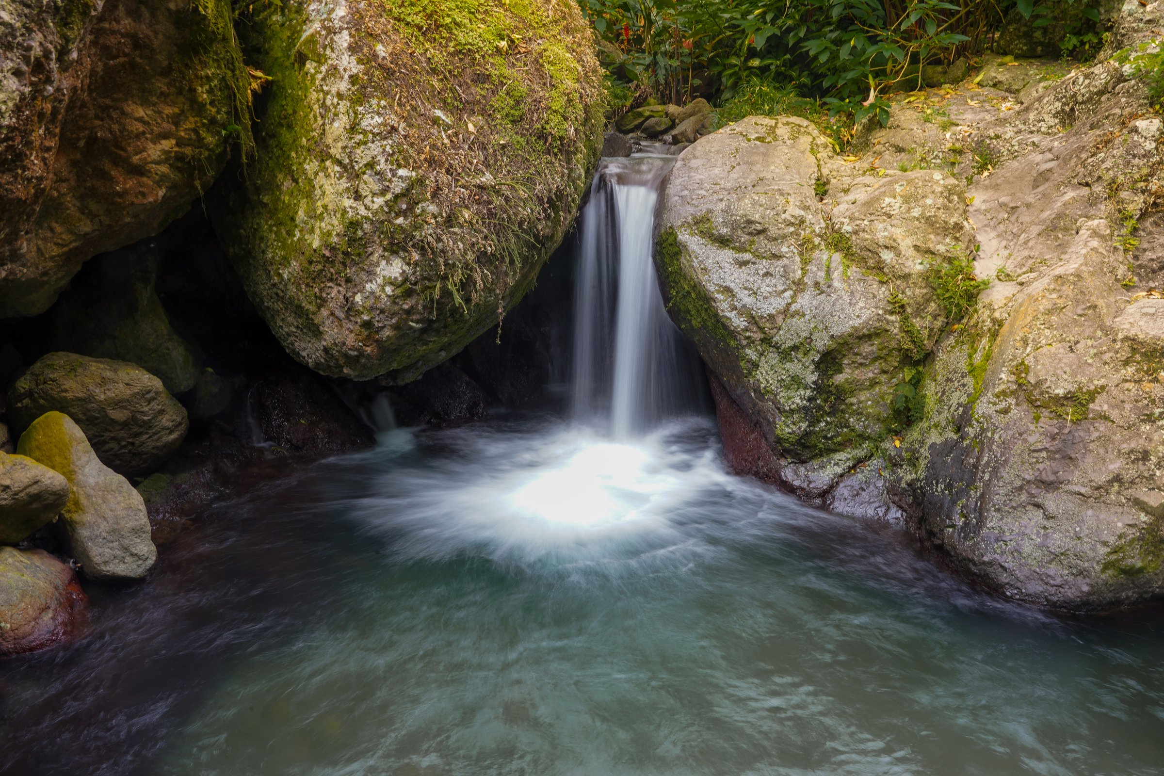 Silky waterfall between mossy boulders